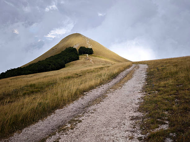 View at the Pizzo Meta from Piani di Ragnòlo, a vast plateau of the Sibillini Mountains, which extends between the Municipalities of Sarnano and Fiastra, Marche, Italy. Pizzo Meta is famous for the boundless panorama of the region and its characteristic cross on the top.