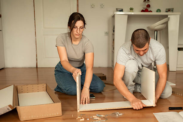 istock Couple Assembling New Wooden Shelf in Their Apartment 2242559384