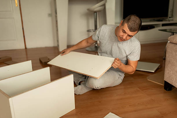 istock Man Assembling Wooden Shelf in Living Room 2242559446