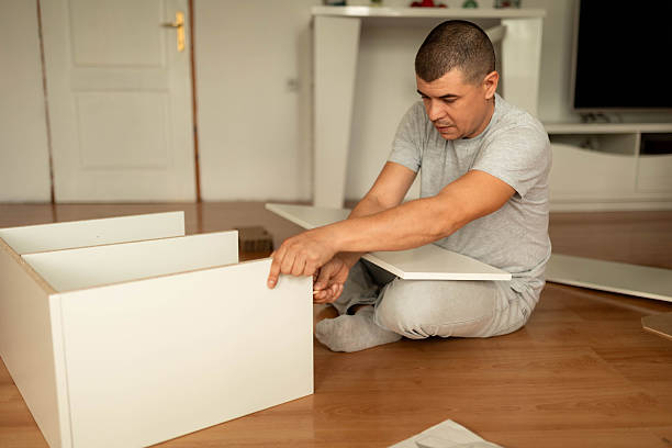 istock Man Assembling Wooden Shelf in Living Room 2242559449