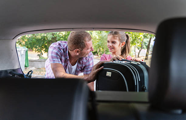 istock Father and Daughter Smiling While Packing Suitcase 2242559884