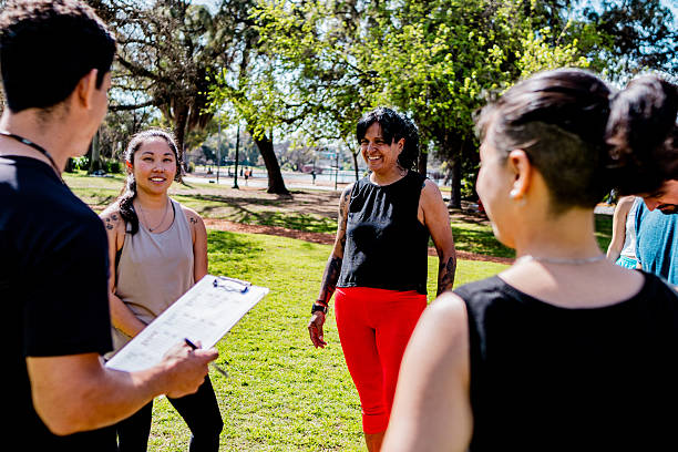 istock Mature trainer talking to athletes on public park 2242560408