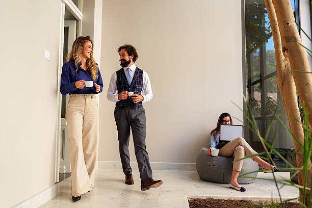 istock Business colleagues enjoying coffee break and conversation in modern office 2242560552
