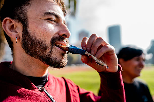Mid adult man eating protein bar on public park