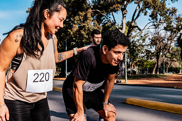 Energetic male runner jumping with joy during marathon race. Celebratory moment captured as athlete reaches the finish line in outdoor event. Bright and dynamic expression of success and achievement.