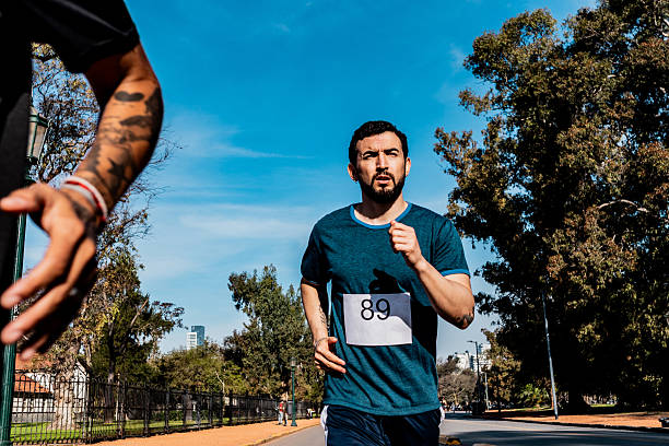 Mid adult man running during marathon on public park
