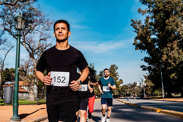 istock Mature man running during marathon on public park 2242560873