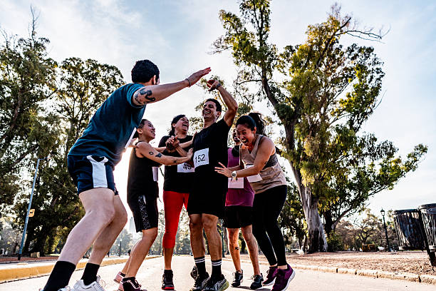 istock Friends celebrating after marathon on public park 2242561331