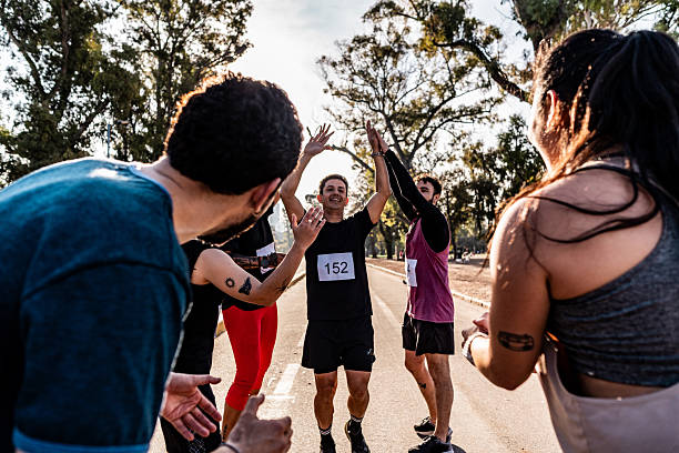 istock Friends celebrating after marathon on public park 2242561467