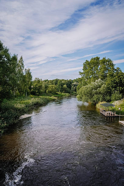 istock Serene river flows through lush greenery under a bright blue sky, showcasing the beauty of nature and tranquility in a peaceful landscape setting 2242564272