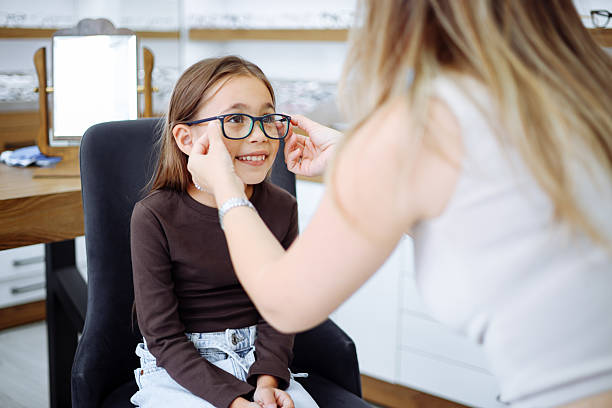 Picture of child optometry female optometrist optician doctor examines eyesight of little girl