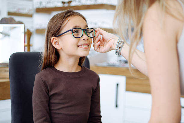 istock Lttle girl choosing new eyewear in optical store 2242565556