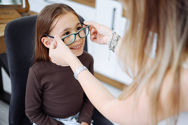 istock Lttle girl choosing new eyewear in optical store 2242565618