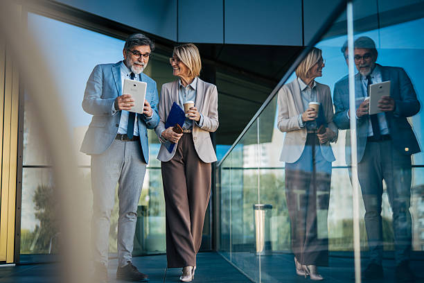 istock Business people discussing ideas using tablet outdoors 2242567590