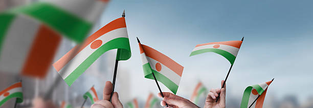 istock Niger flags in their hands on a blurred urban background 2242568542