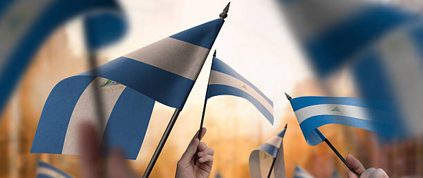 istock Nicaragua flags in their hands on a blurred urban background 2242568563