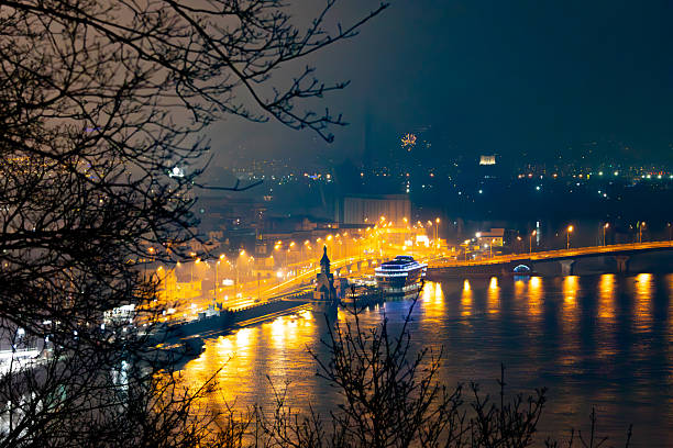 Captivating low light night view of the illuminated Kyiv River Port and Podil embankment with bright lights reflecting on the Dnipro River.