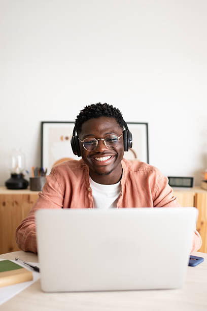 istock Young man working from home smiling and wearing headphones 2242570602