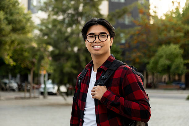 istock Smiling young adult student walking on campus 2242570614