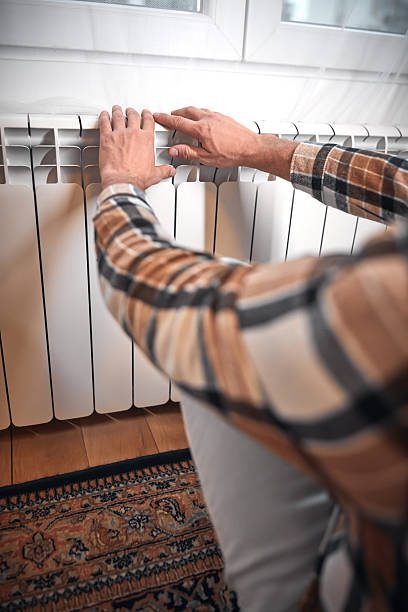 istock Man heating on a chilly winter day, energy and gas crisis, cold room, heating problems. 2242570845