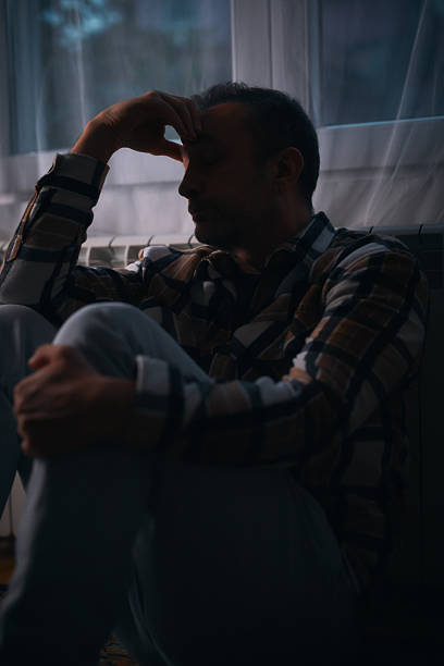istock Man with depression and headache sitting on a chair at home. 2242571745
