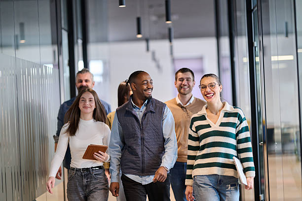 istock Group of confident professionals walking together through a bright modern office corridor. Concept of teamwork, diversity, success, collaboration, and positive workplace culture. 2242571789