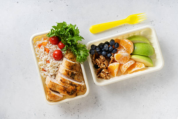 istock Lunch box with chicken, rice, vegetables, tomatoes, salad, fruits 2242572124