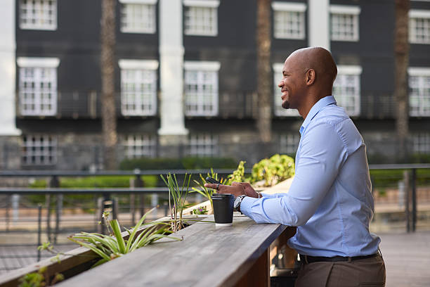 istock Professional black businessman in blue shirt enjoying coffee while working outdoors at a modern campus 2242573079