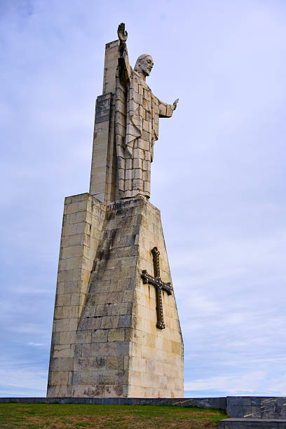 istock Tall Christ monument with raised hand towering against clear sky 2242573888