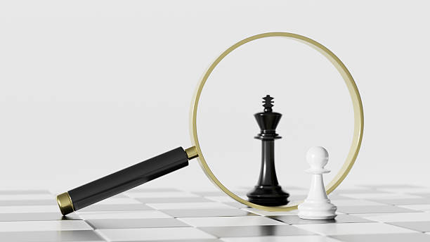 istock Magnifying Glass Over Chessboard Highlighting Black King and White Pawn in Focus 2242574041