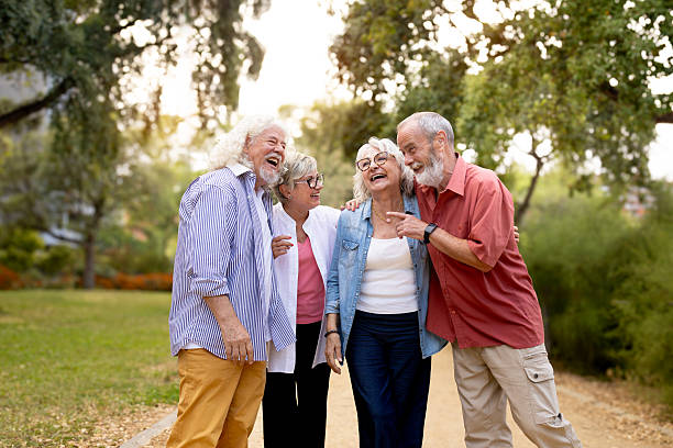 istock Senior friends laughing walking together in a park 2242574595