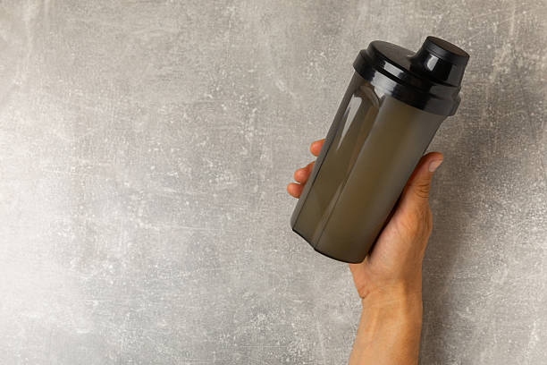 istock Protein shake with protein powder on a colored background. The powder is mixed with water or milk. A dietary supplement for a balanced diet. Whey protein. Fitness and gym diet nutrition. 2242577576