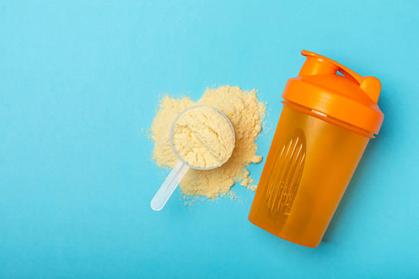 istock Protein shake with protein powder on a colored background. The powder is mixed with water or milk. A dietary supplement for a balanced diet. Whey protein. Fitness and gym diet nutrition. 2242577618