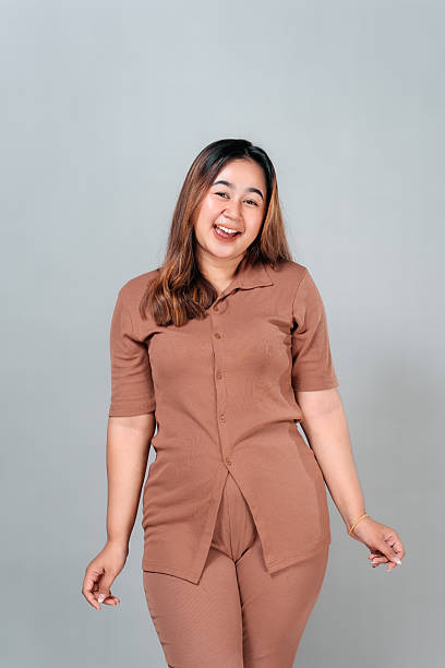 Charming young Asian woman smiling with an expression of surprise and delight while looking camera. Her joyful face and natural pose convey curiosity, wonder, and positivity.