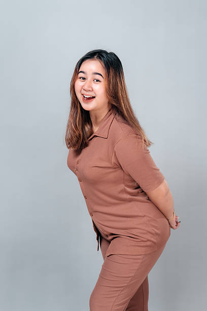 istock Smiling young Asian woman leaning forward with a joyful, playful expression. Her open mouth and sparkling eyes express excitement, happiness, and friendly energy on camera. 2242578602