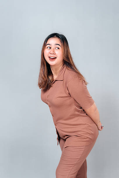 istock Smiling young Asian woman leaning forward with a joyful, playful expression. Her open mouth and sparkling eyes express excitement, happiness, and friendly energy on camera. 2242578607