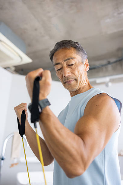 Senior Japanese man training in bathroom in bright morning - low angle view