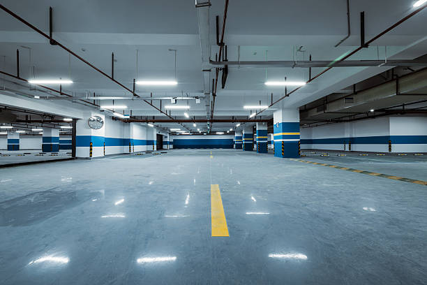 istock Empty underground parking lot with concrete floor and bright fluorescent lighting in a modern commercial building. 2242584811