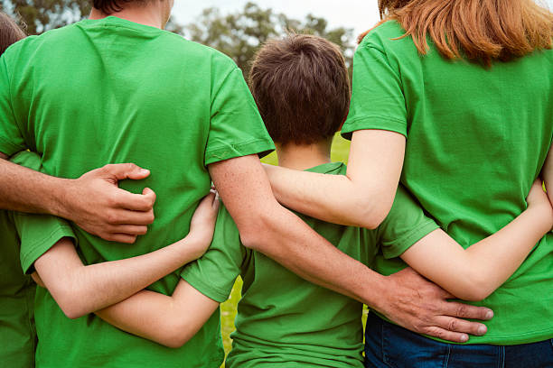 istock Volunteers with arms around in park 2242595779