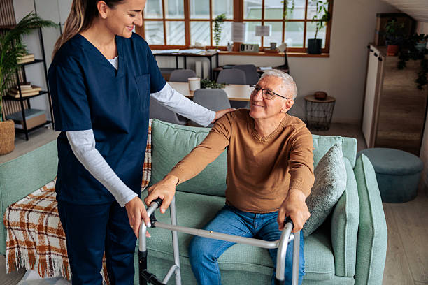 istock Nurse Assisting Senior Man to Stand Up Using a Walker 2242596121