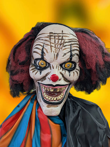 istock Creepy clown figure with bright colors and a sinister expression in a festive setting during autumn 2242597490