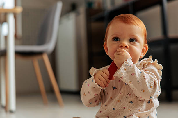 istock Baby Exploring a Wooden Object with Her Mouth 2242598750