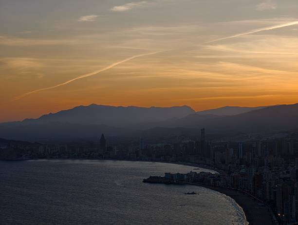 istock sunset harbor with mountain backdrop, silhouette of harbor during amber sunset with distant 2242599274