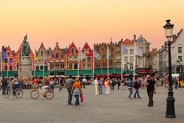 Bruges, Belgium - October 4, 2014: Sunset on the central square Grote Markt. Ancient Bruges (Brugge) historical center is a prominent World Heritage Site of UNESCO. European tourism