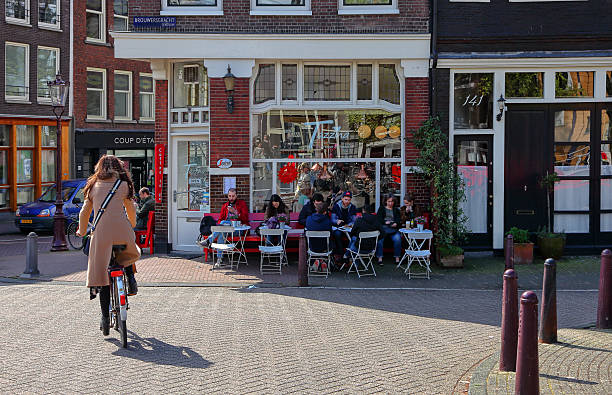 Amsterdam, Netherlands -  April 8, 2017: People enjoy a warm spring day and drink coffee outdoors at a street cafe