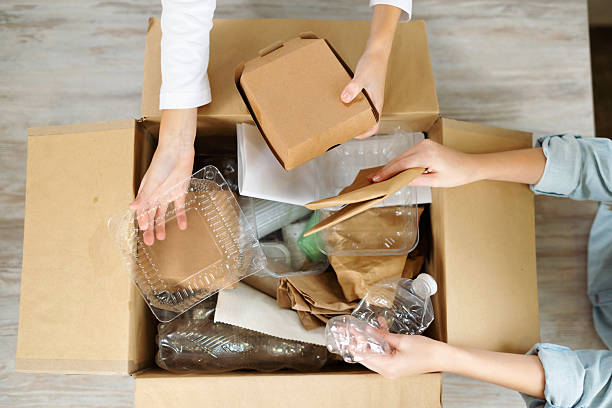 istock Kids hands sort paper and plastic into separate containers in the kitchen at home. Top view. Waste segregation, waste sorting, waste recycle. 2242604010