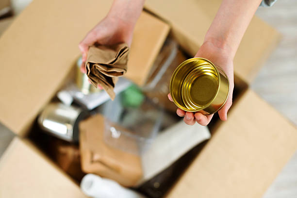 istock Kids hands sort paper and plastic into separate containers in the kitchen at home. Top view. Waste segregation, waste sorting, waste recycle. 2242604040