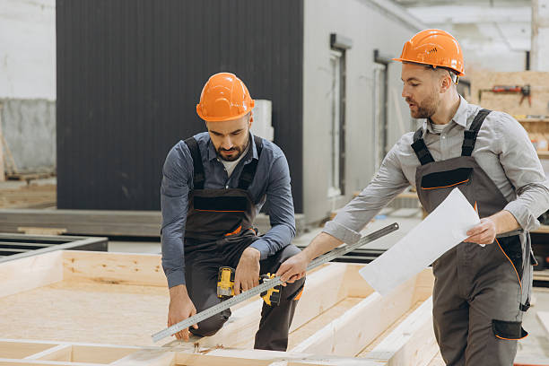 istock Construction workers measuring wooden planks for prefabricated building 2242609199