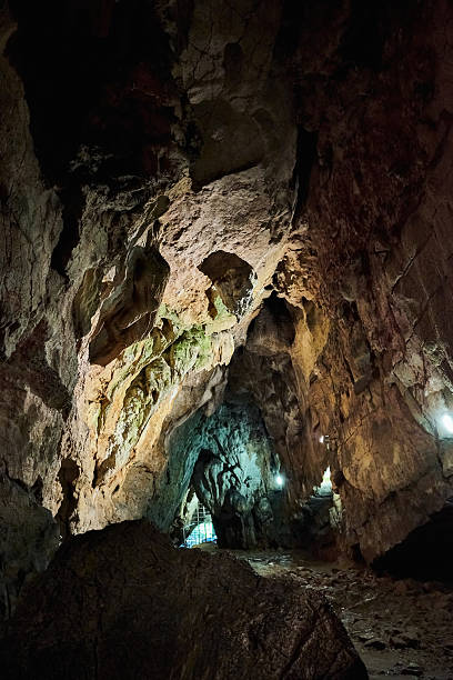 Background photo of the cave inside the mountain. Natural formations are visible in the illuminated cave. Abstract shapes were formed with the effects of shadow and light. Shot with a full frame camera.