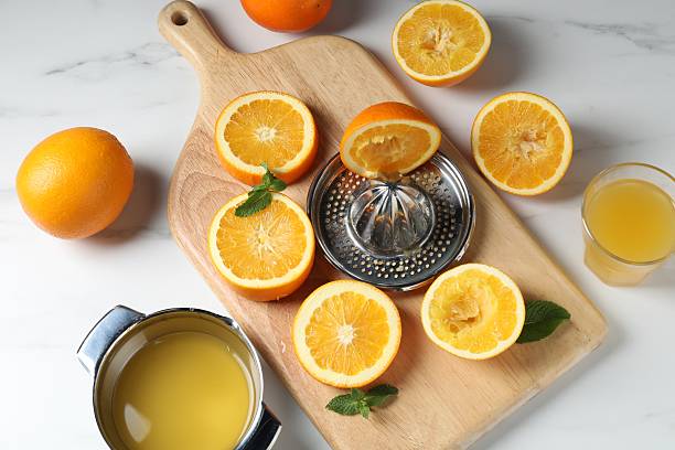 istock Squeezer with oranges, mint and fresh juice on white table, flat lay 2242612429